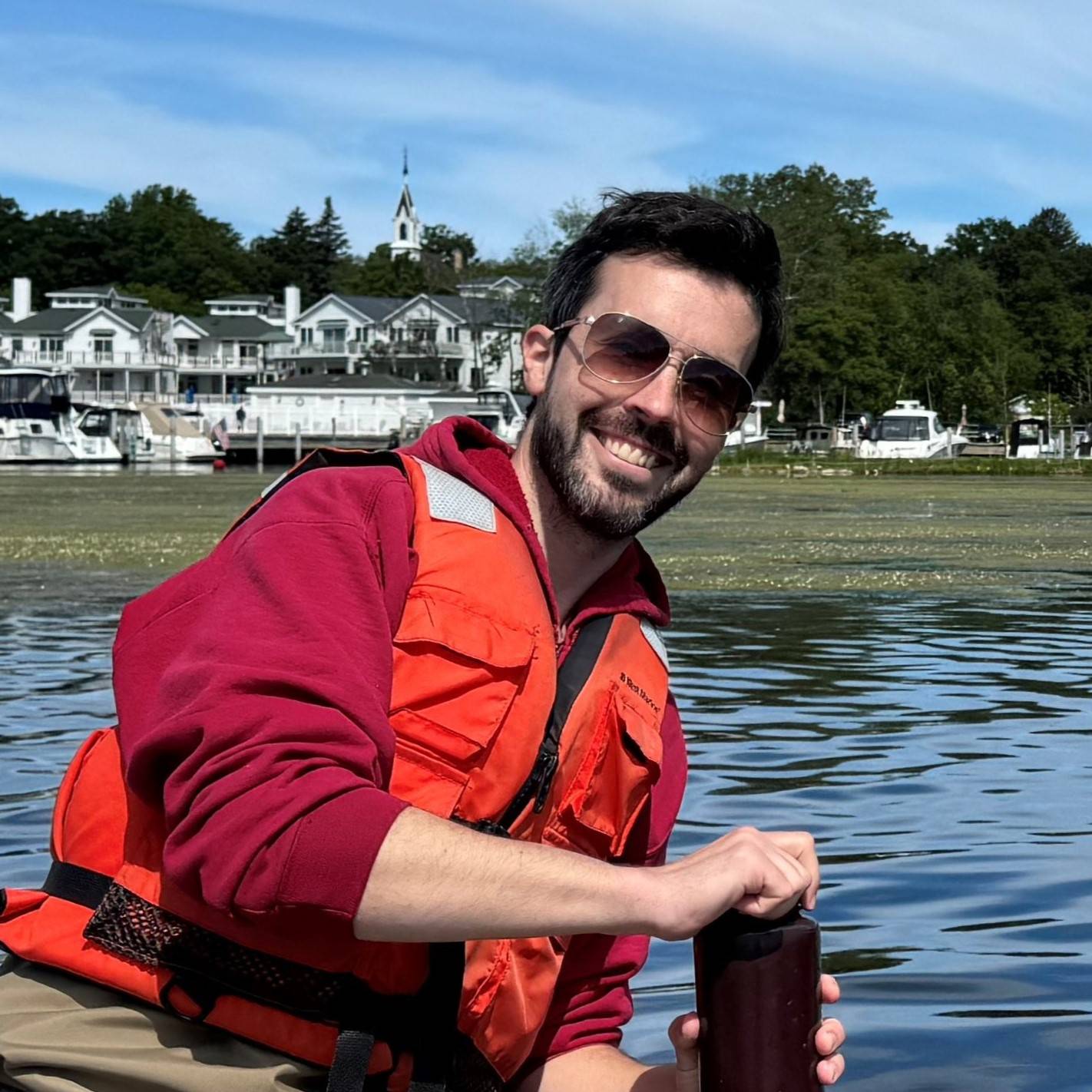 Michael Hassett collects a water sample from a lake.